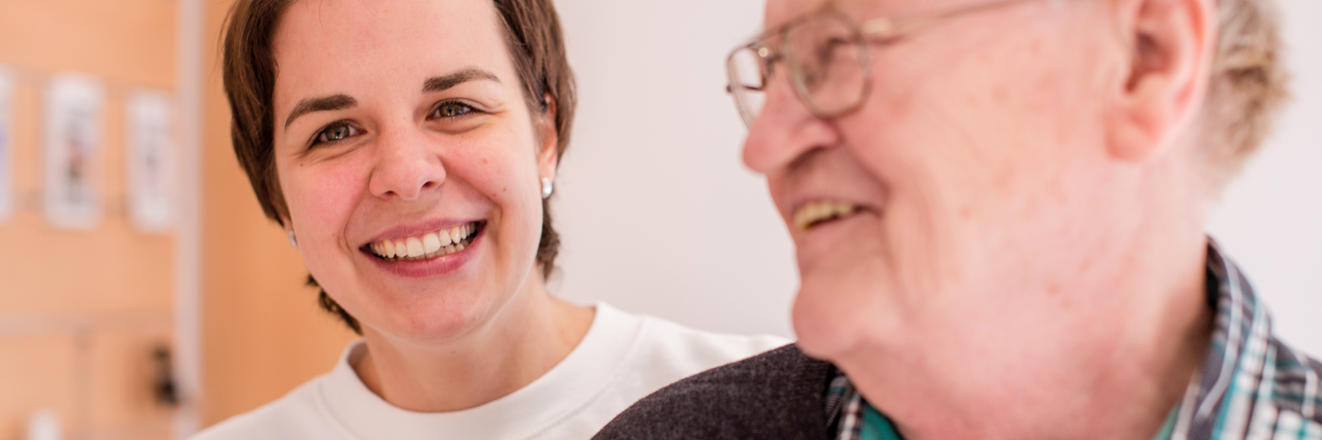 Lachende Betreuerin mit einem Senior