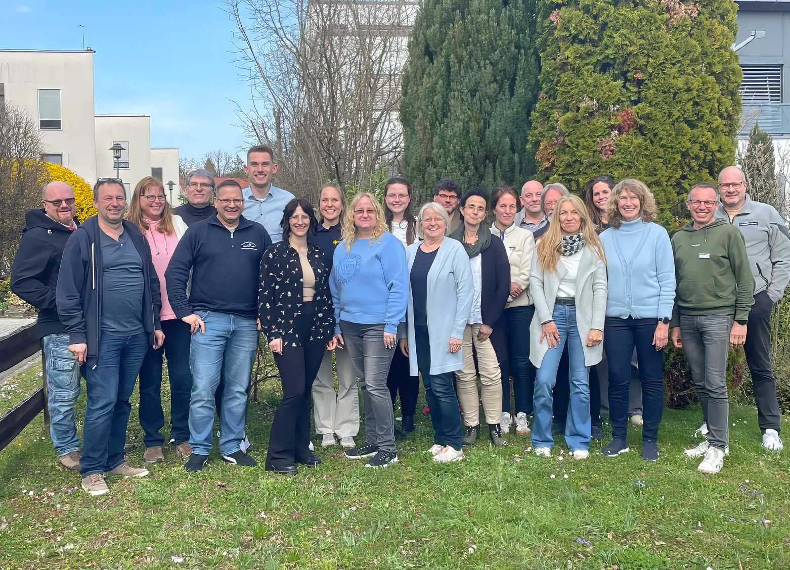 Das Bild zeigt die Gruppe der Absolventinnen udn Absoventenn durch ehrenamtliche Helferpersonen im Gespräch