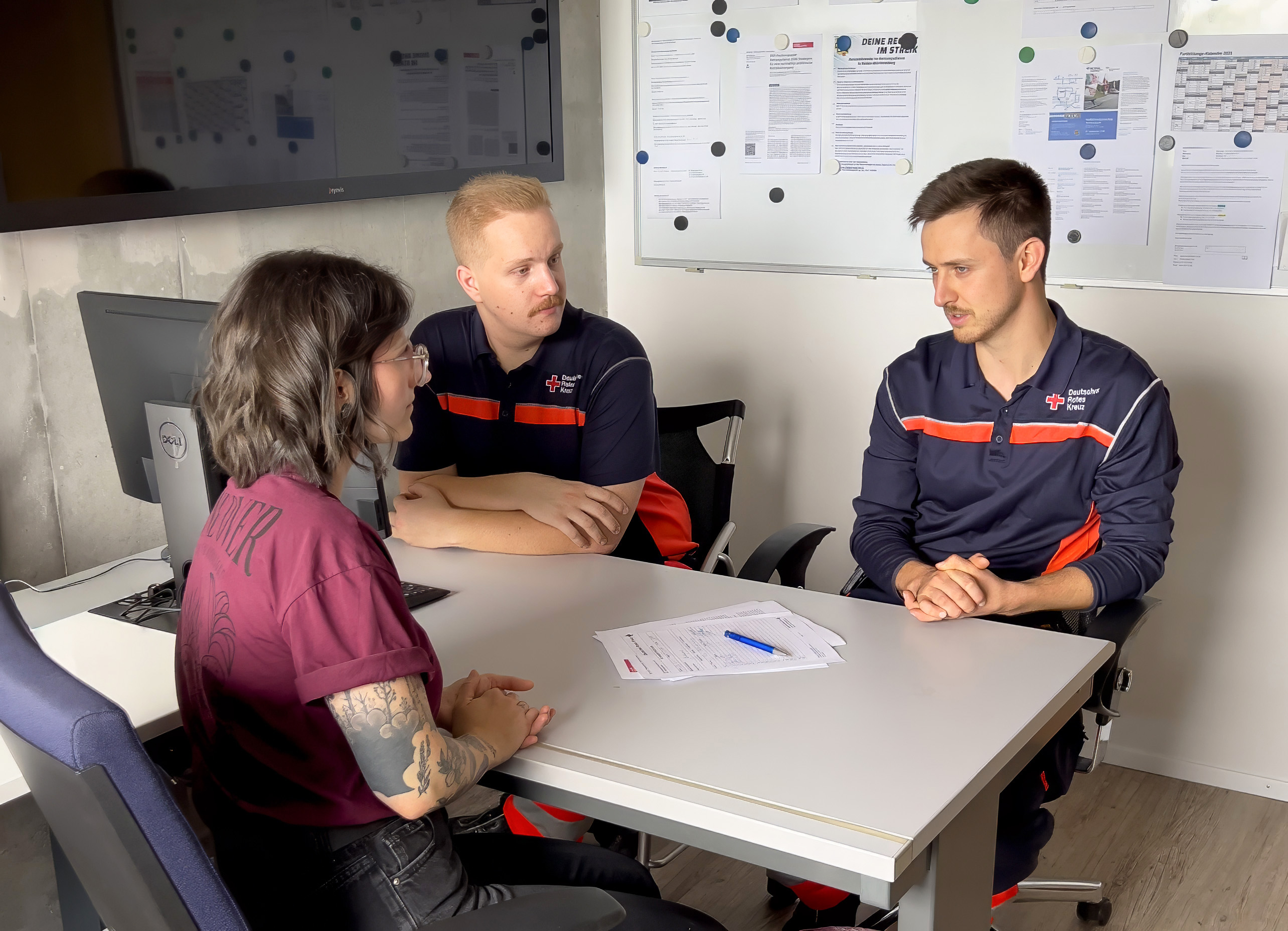 Das Bild zeigt drei Personen im Gespräch