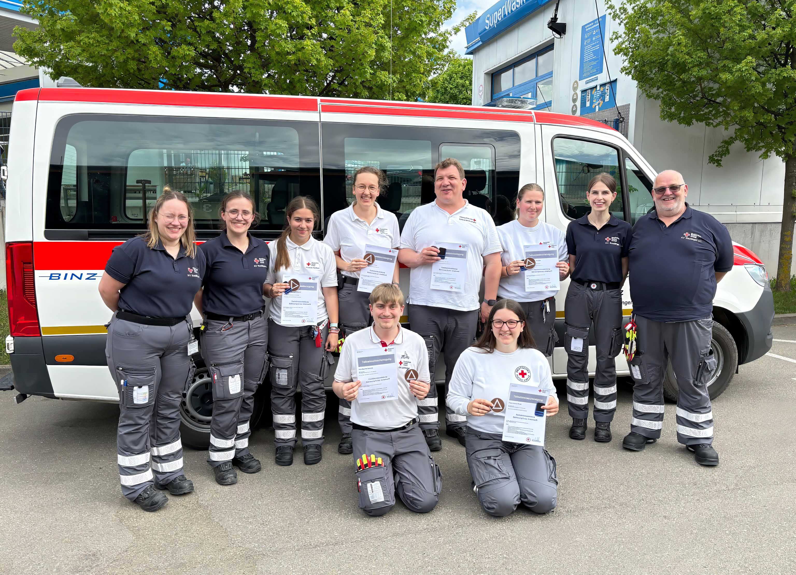 Die Teilnehmende der Fachausbildung Betruungsdienst stehen vor einem Einsatzfahrzeug. 