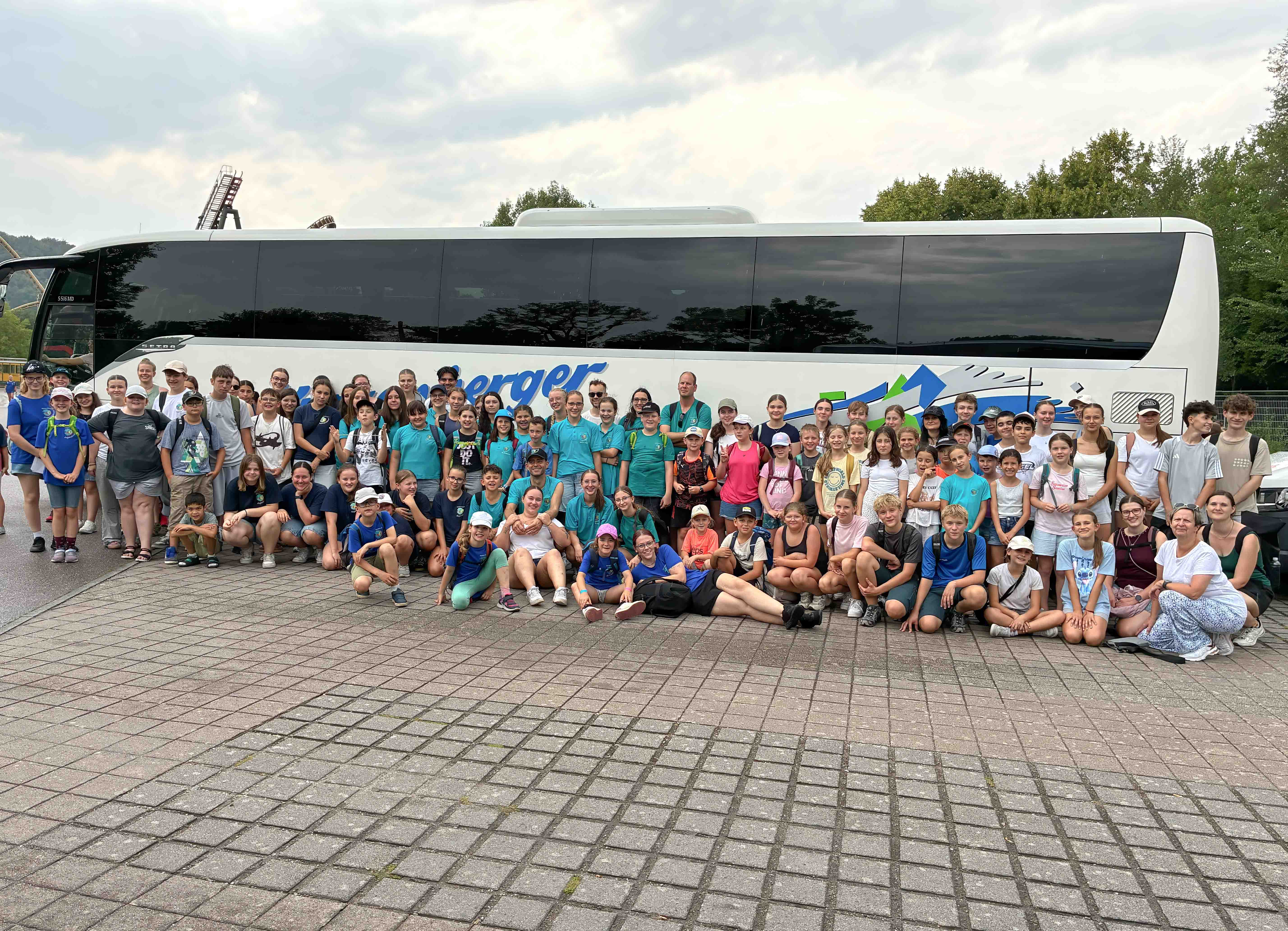 Das Bild zeigt das Jugendrotkreuz vor dem Reisebus am Eingang des Freizeitparks Tripsdrill.