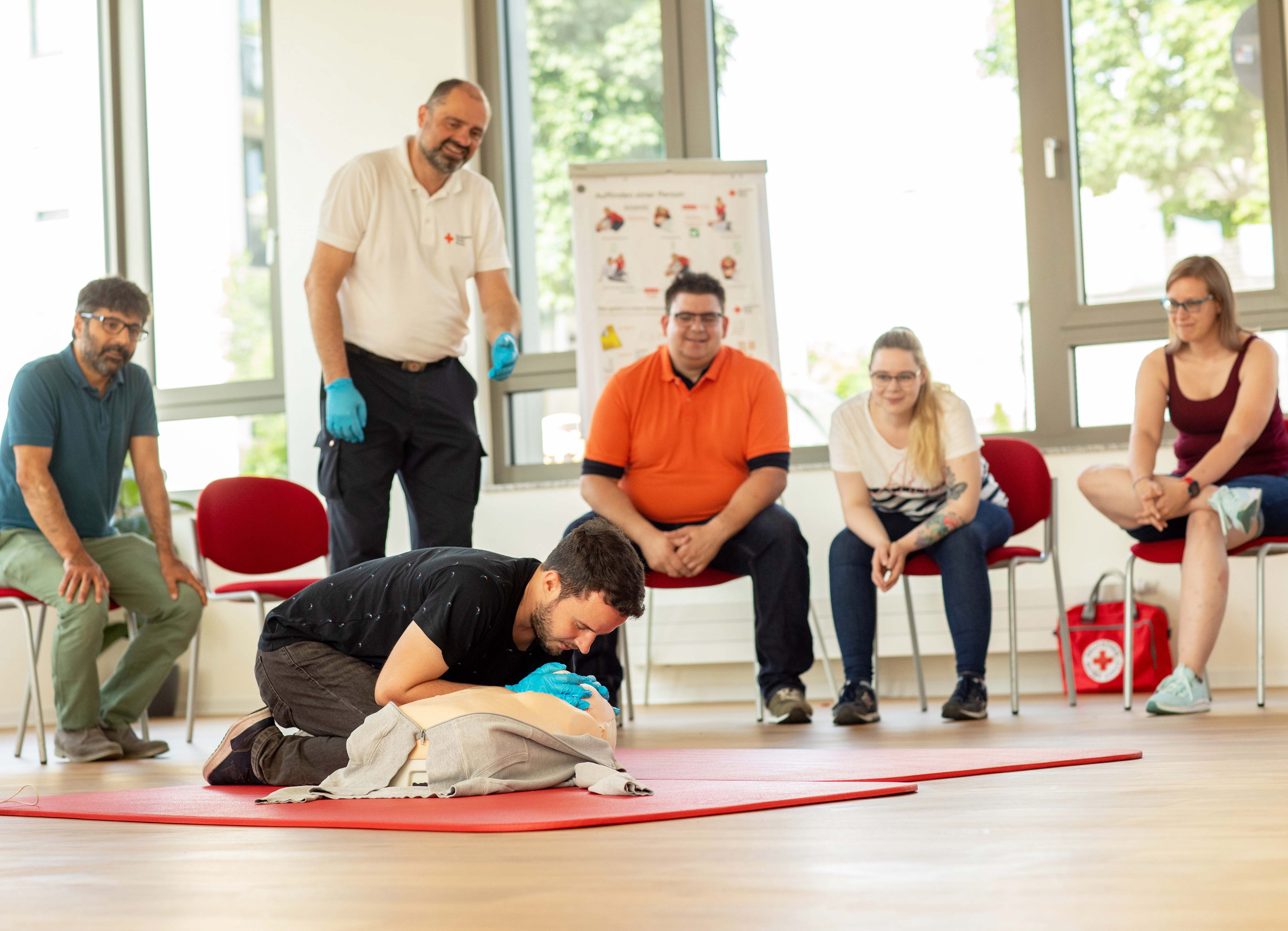 Übung der Herzmassage an einer Puppe