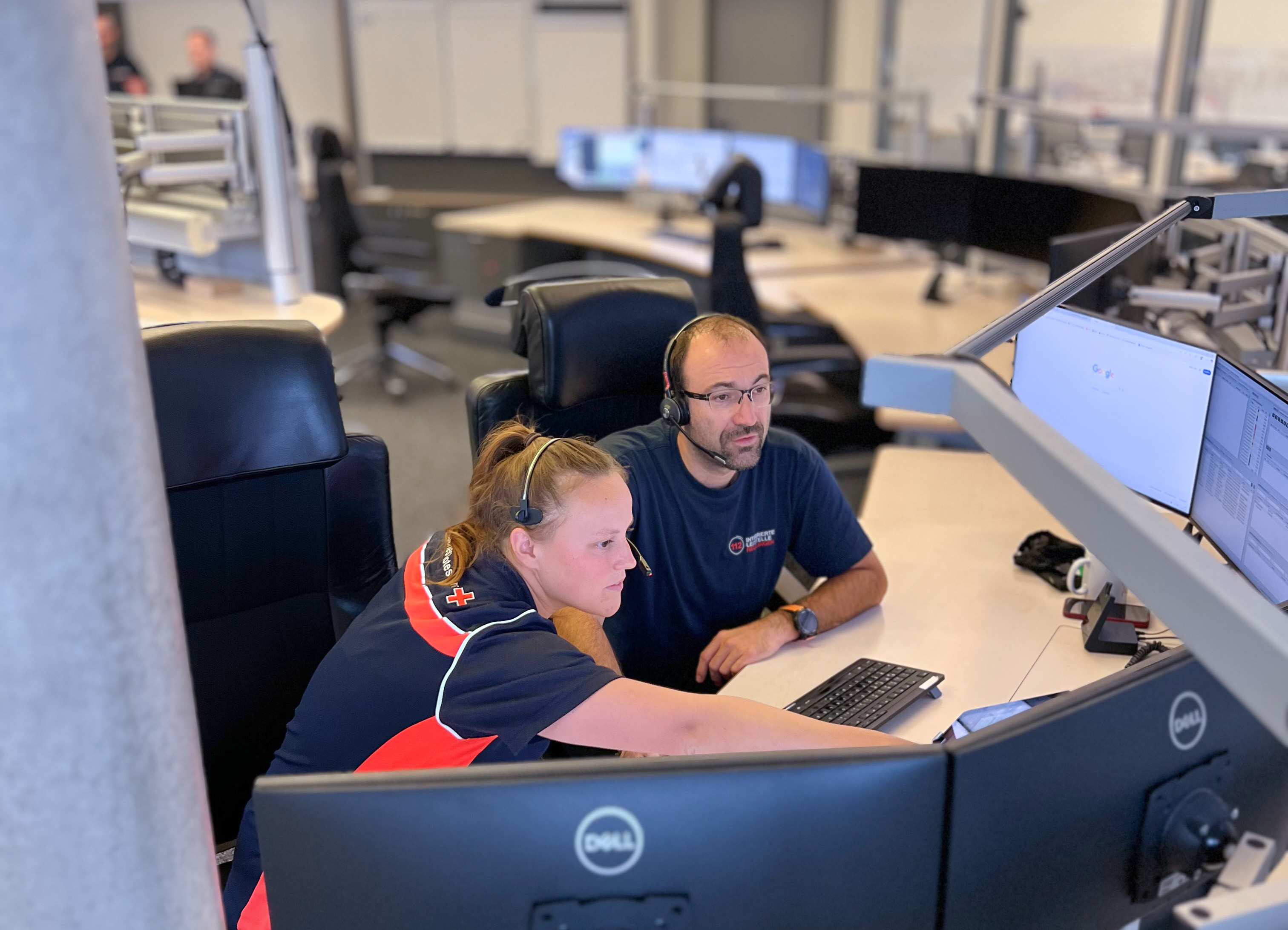 Eine Disponentin und ein Disponent sitzen am Arbeitsplatz