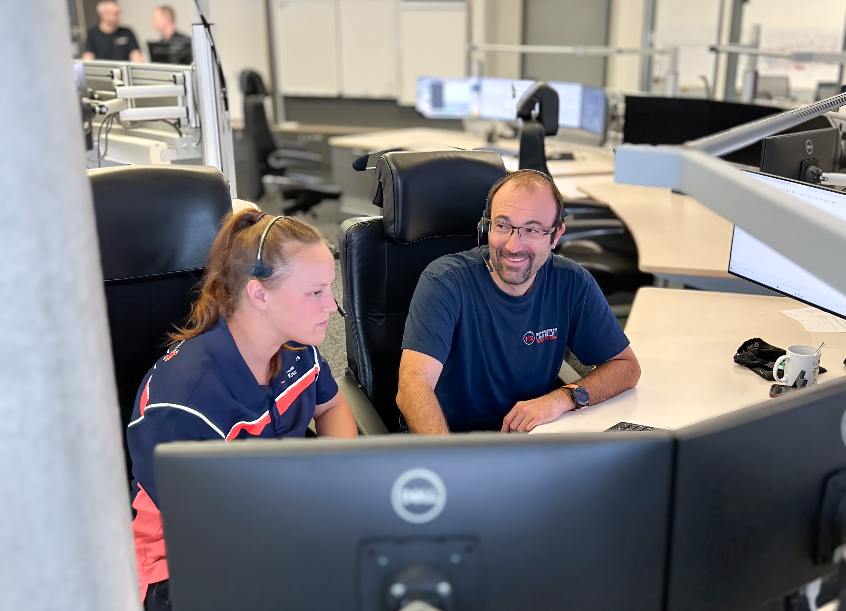 DRK-Mitarbeiter achat auf mehrere Monitore in der Leitstelle